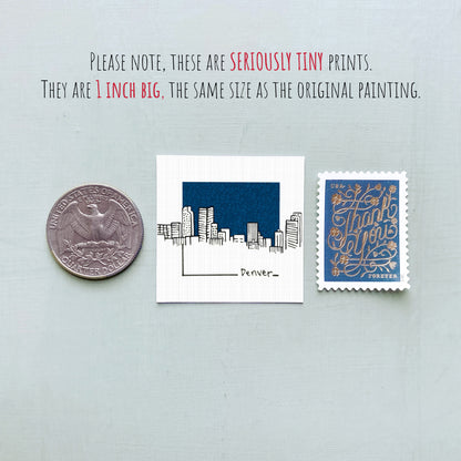 a collection of three items: a quarter, a small square print of a city skyline, and a postage stamp.