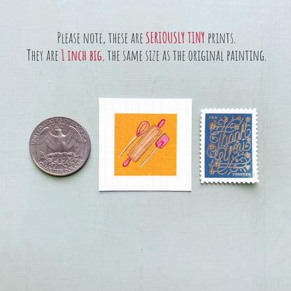 three small items: a quarter, a square with an illustration of a rolling pin and a wooden spoon, and a blue postage stamp with gold lettering.
