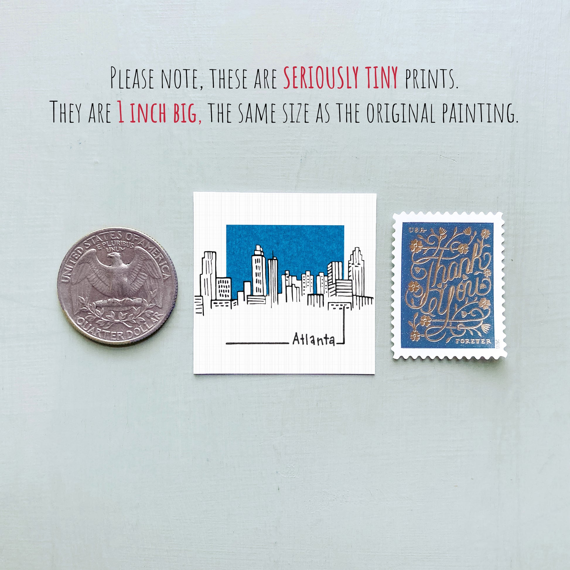 three different objects: a quarter, a small paper print of Atlanta, and a postage stamp.
