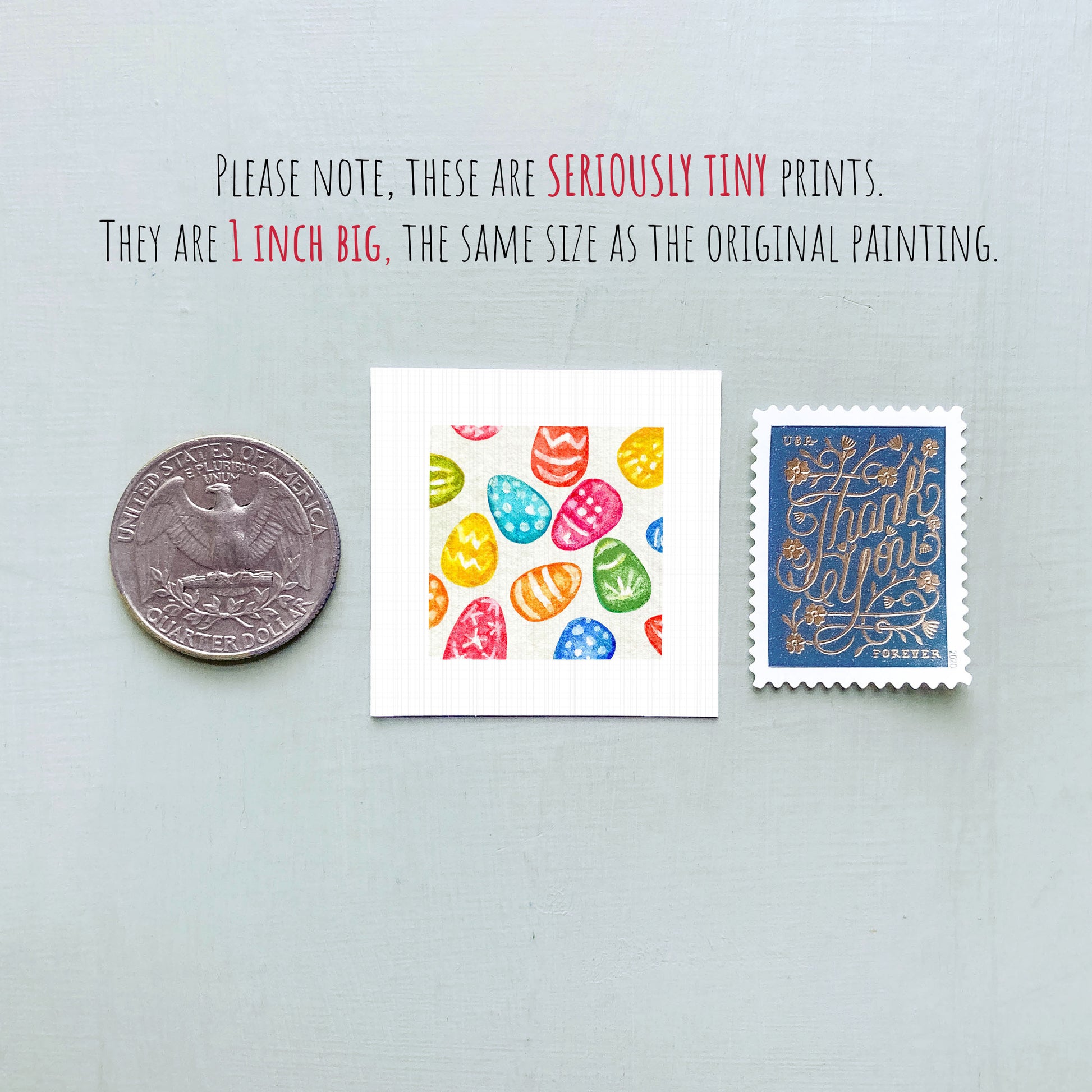 three small prints: a silver coin, a white square with a colorful Easter egg pattern, and a blue postage stamp with gold lettering.