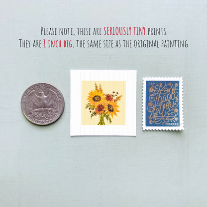 three small prints: a silver coin, a white square print of a flower, and a blue postage stamp.