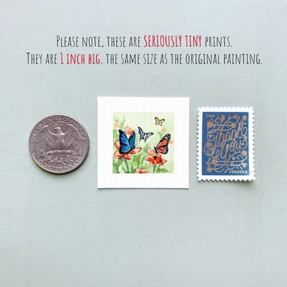 three small prints: a silver coin, a square print of butterflies on flowers, and a blue postage stamp with gold lettering.