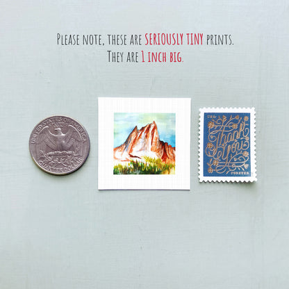 a collection of three small items: a quarter, a postcard with a mountain landscape, and a postage stamp.