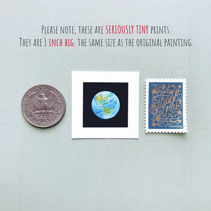 three small prints: a United States quarter, a small framed print of the Earth, and a postage stamp.