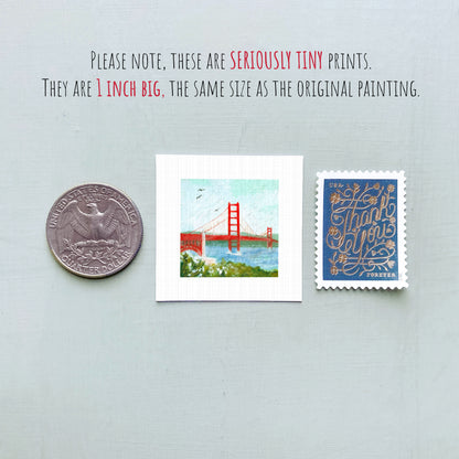 a collection of three small items: a quarter, a postage stamp, and a painting of the Golden Gate Bridge.
