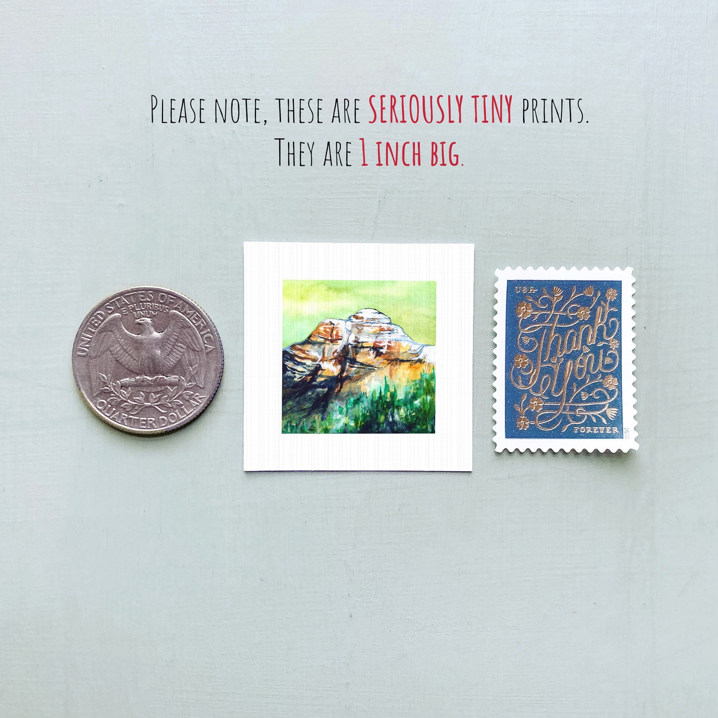 a collection of three small items: a quarter, a postage stamp, and a painting of a mountain.