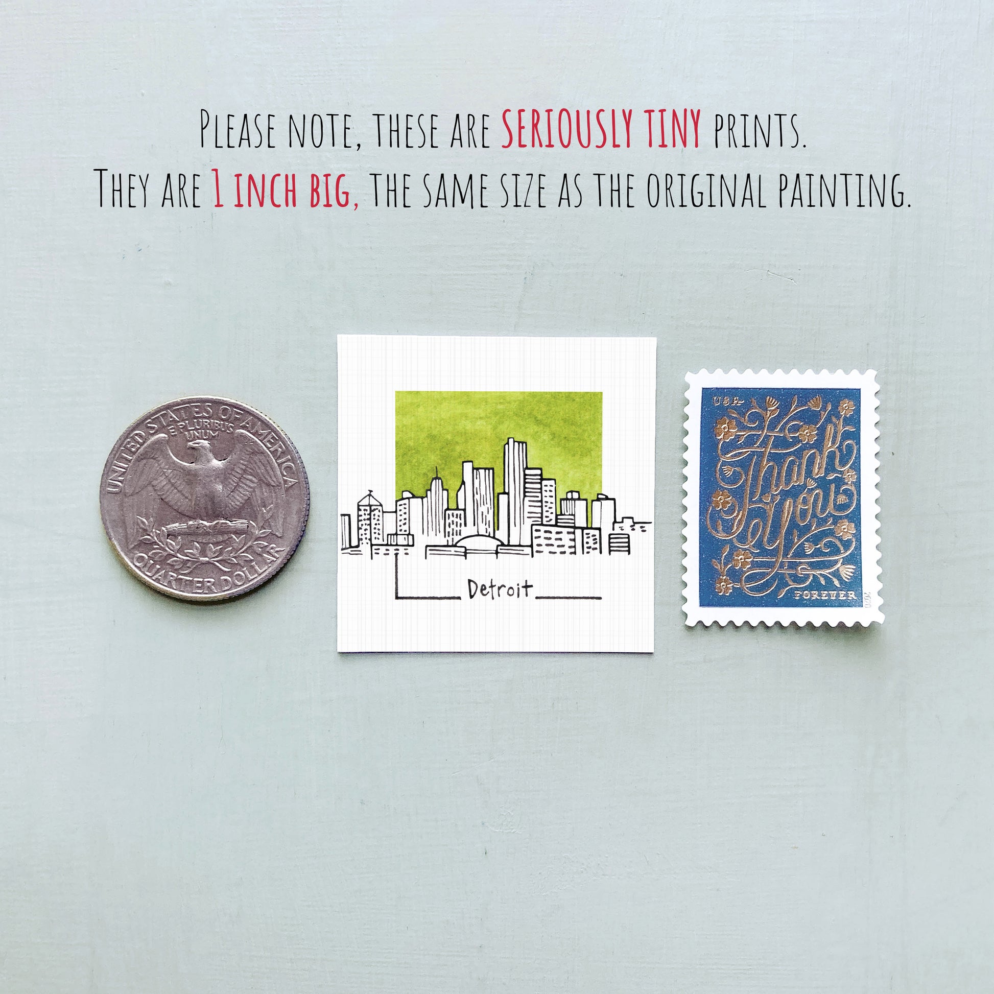 a collection of three objects: a quarter, a small square print of a city skyline, and a postage stamp.