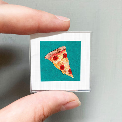 A hand is holding a small square with a picture of a slice of pizza on it.