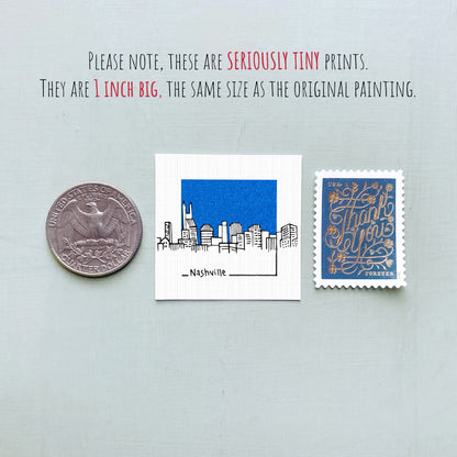 three different objects: a quarter, a small square print with a cityscape illustration, and a postage stamp.