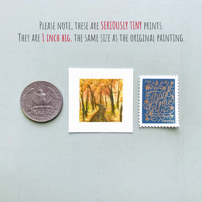 three small artworks or prints, including a coin, a painting of a forest path, and a postage stamp, all placed on a light blue background.