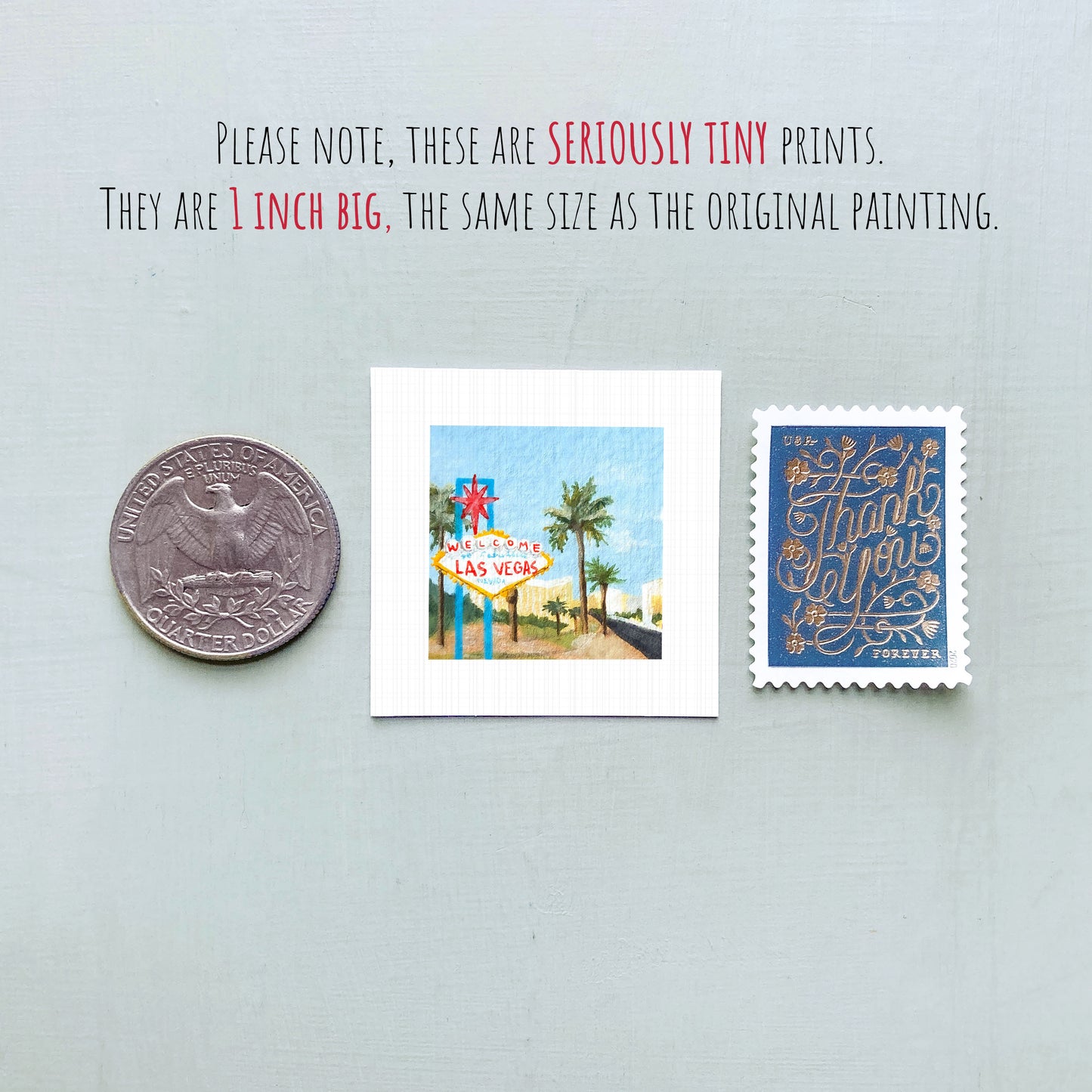 three small prints: a United States quarter, a miniature painting of Las Vegas, and a postage stamp.