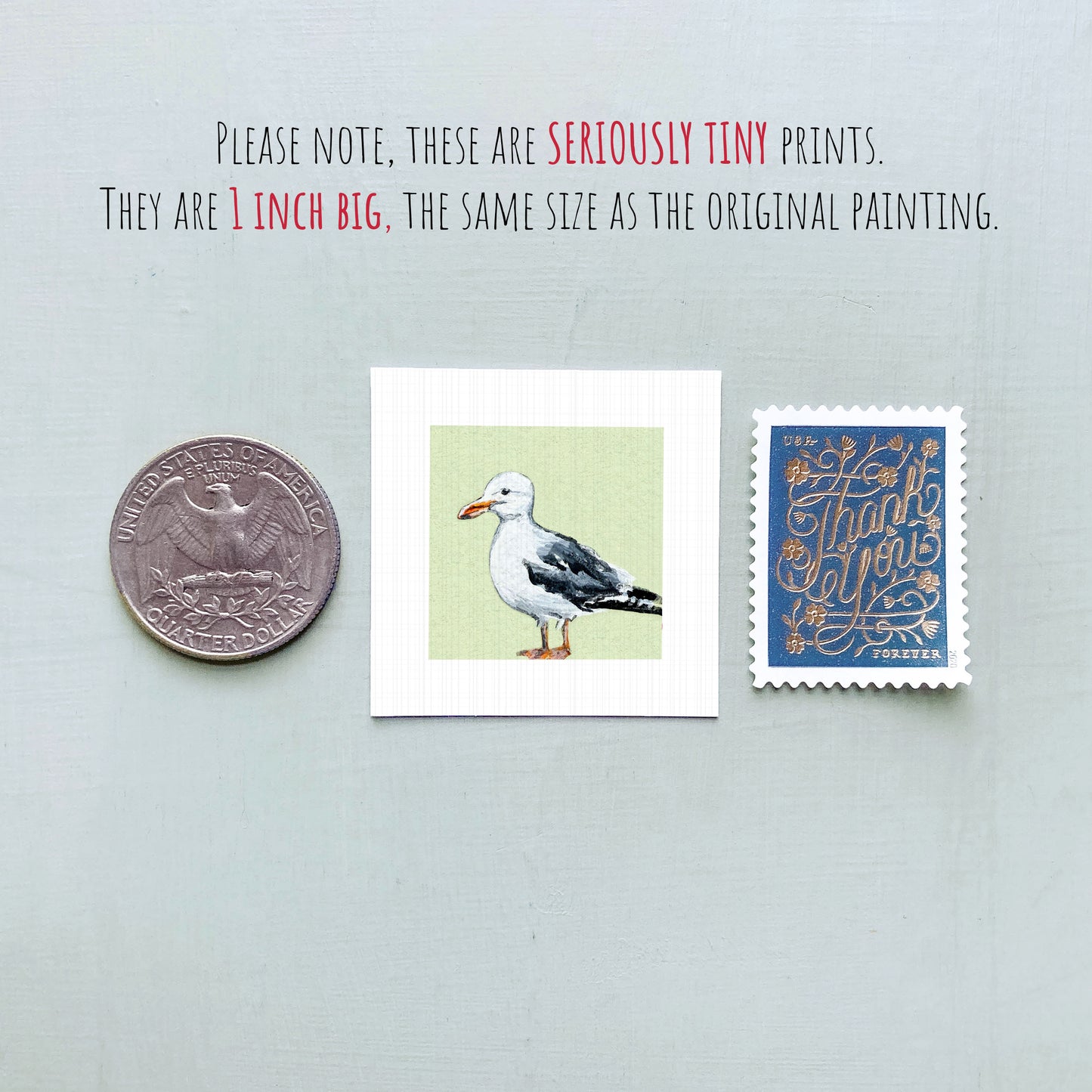 a small, 1-inch-big painting of a seagull, a United States quarter, and a blue postage stamp.