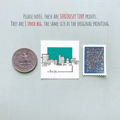 a collection of three small items: a quarter, a square with a drawing of a city, and a postage stamp.