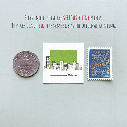 three different objects: a United States quarter, a small square print with a cityscape illustration, and a blue postage stamp.