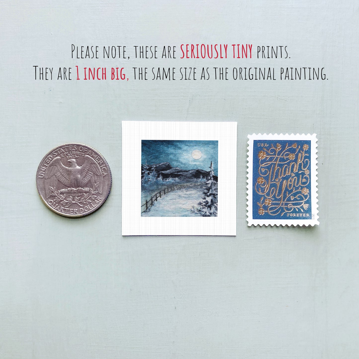three small prints: a quarter, a postage stamp, and a painting of a snowy landscape.