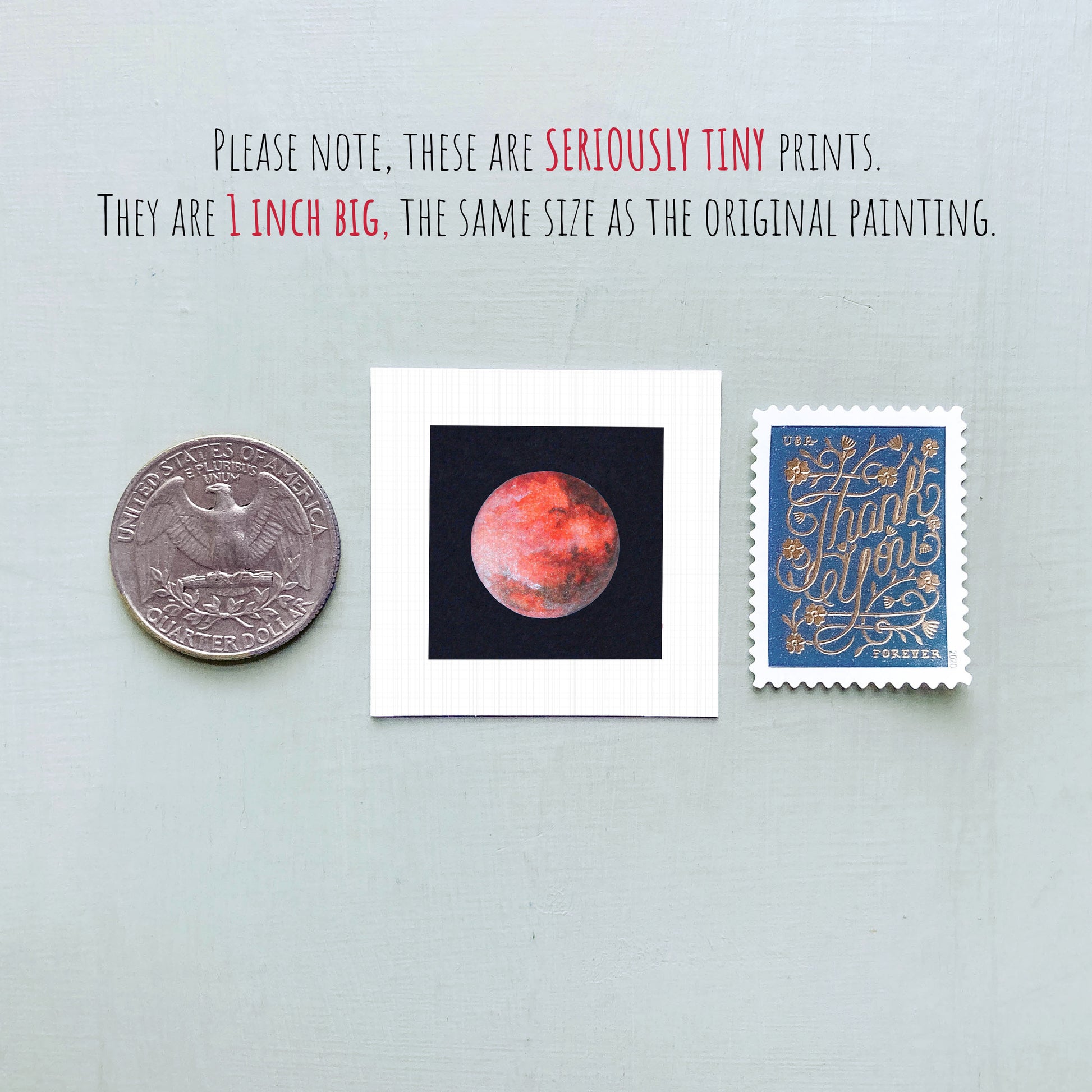three small prints: a silver coin, a white square print of a red planet, and a blue postage stamp with gold lettering.