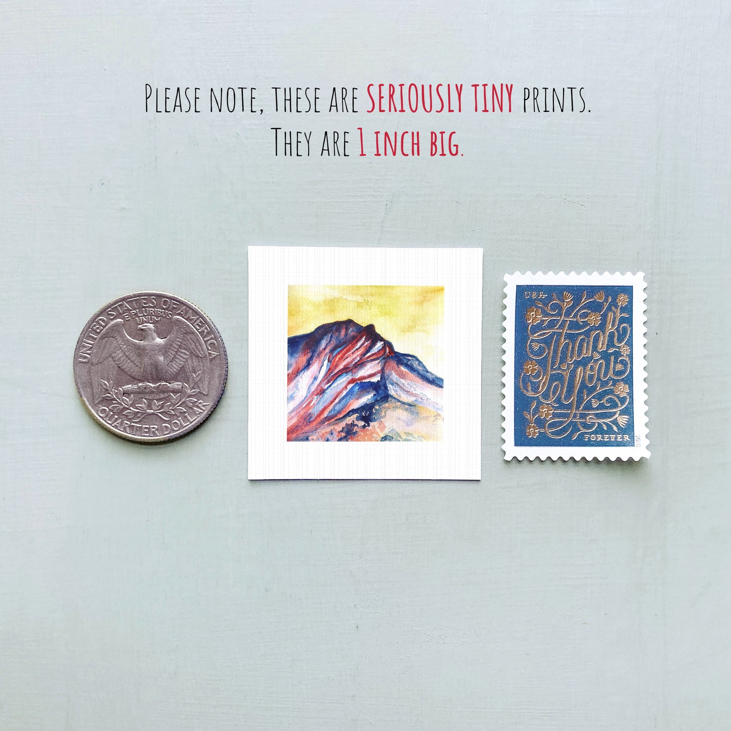 a collection of three small items: a quarter, a painting of a mountain, and a postage stamp.