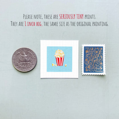 three small, seriously tiny prints: a United States quarter, a small illustration of popcorn, and a postage stamp.