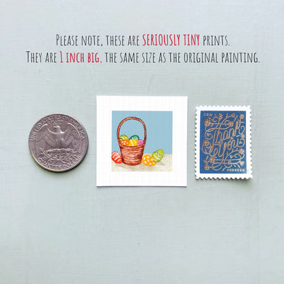 three small prints: a silver coin, a white square print of a basket of Easter eggs, and a blue postage stamp.
