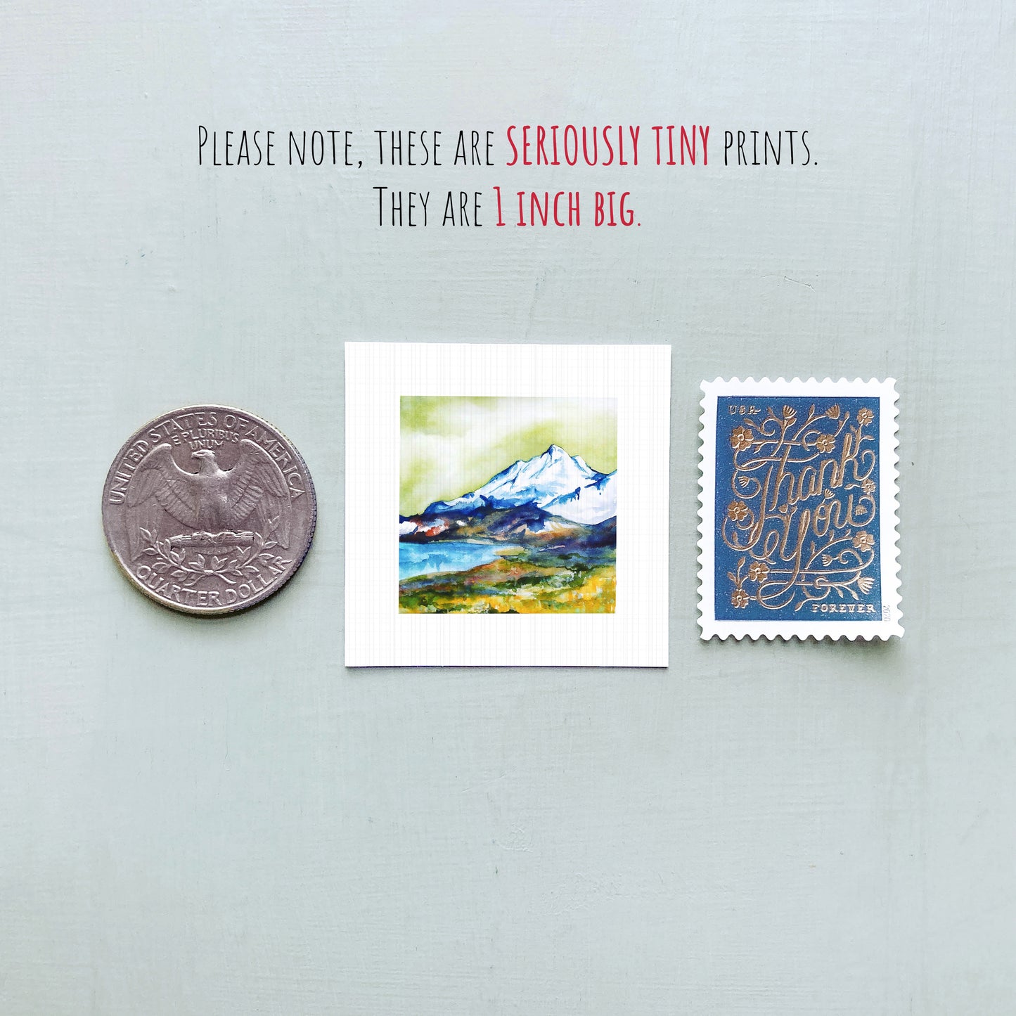 a collection of three small items: a quarter, a postcard with a mountain landscape, and a postage stamp.