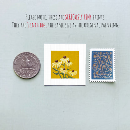 three small prints: a silver coin, a yellow square print with yellow flowers, and a blue postage stamp with gold lettering.