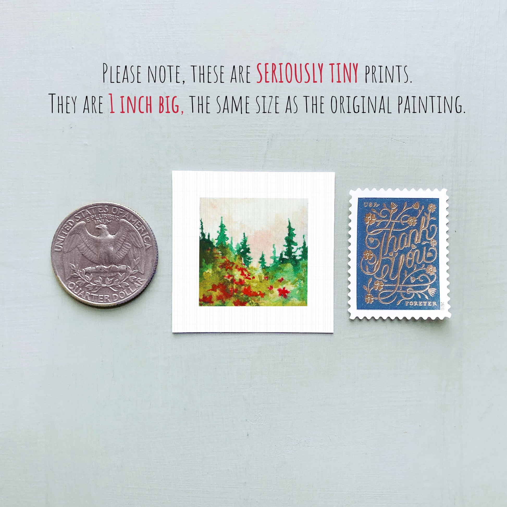 three small prints: a quarter, a square print of a forest scene, and a blue postage stamp with gold lettering.