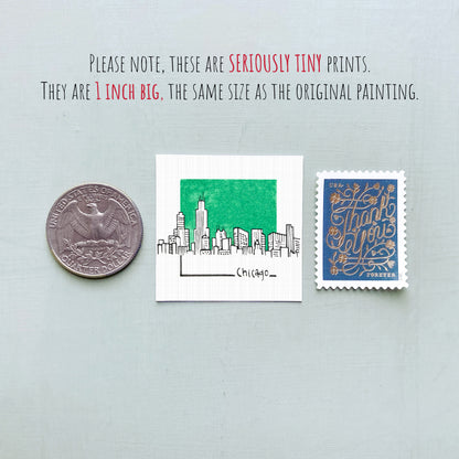 a collection of three small items: a quarter, a stamp, and a miniature painting of a city skyline.