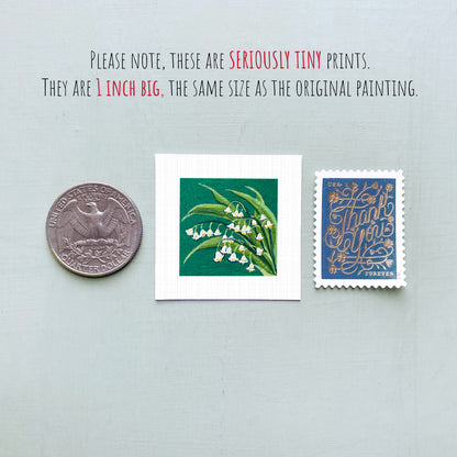 three small prints: a silver coin, a square print of a lily of the valley plant, and a blue postage stamp with gold lettering.