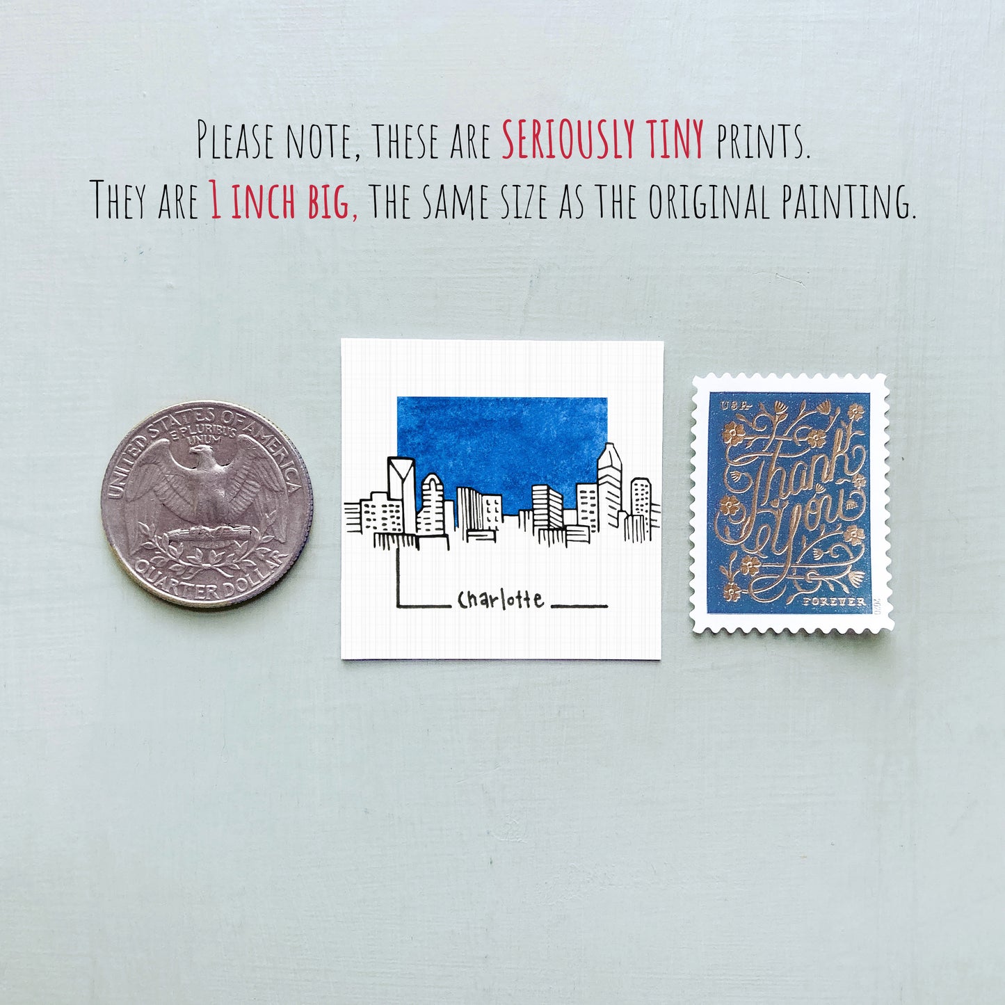three different objects: a quarter, a small square print with a cityscape illustration, and a postage stamp.