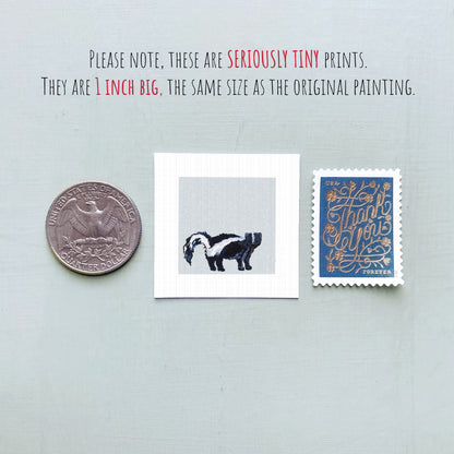 three small items: a quarter, a square print of a black and white animal, and a blue postage stamp with gold lettering.