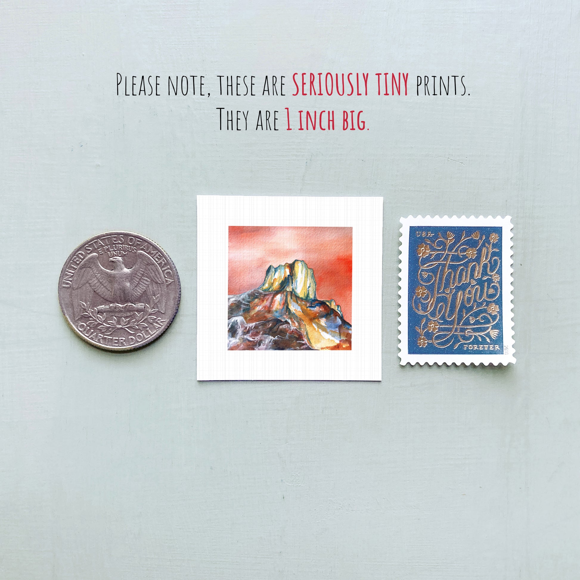 a collection of three small items: a quarter, a square print of a mountain landscape, and a postage stamp.