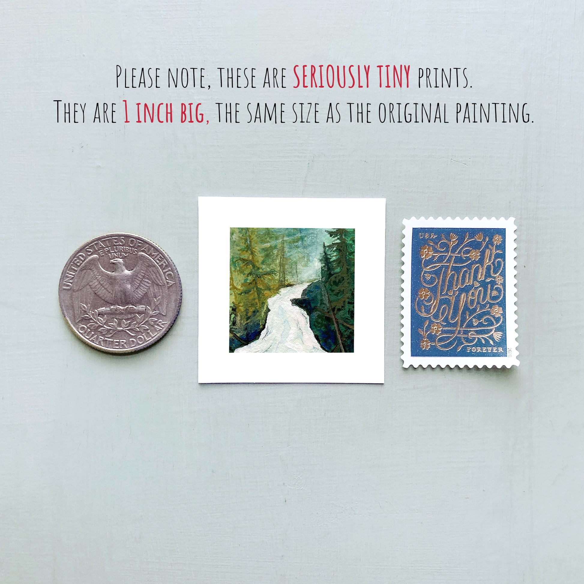 a collection of three objects: a quarter, a small framed print of a forest scene, and a postage stamp.