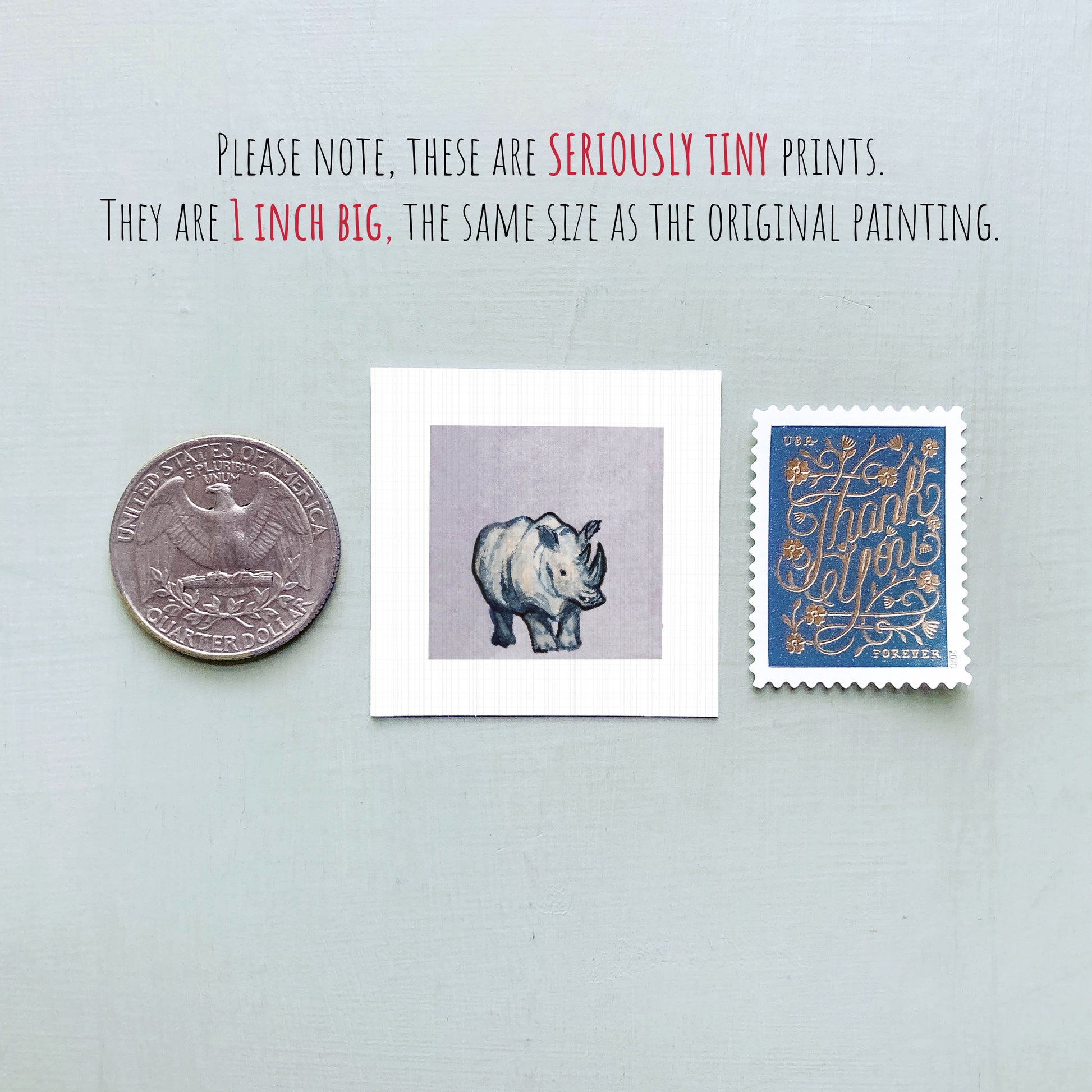 three small prints: a quarter, a postage stamp, and a painting of a rhinoceros.