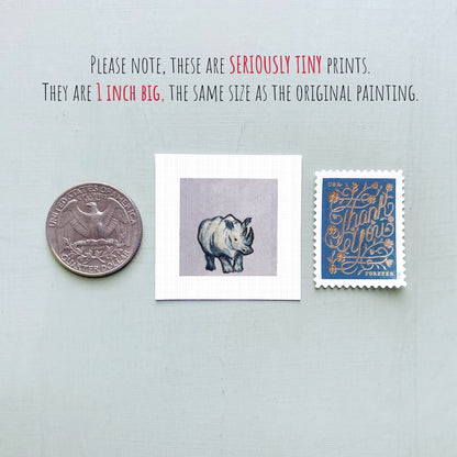 three small prints: a quarter, a postage stamp, and a painting of a rhinoceros.