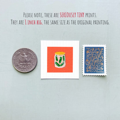 three small items: a quarter, a square with an illustration of a jar of pickles, and a postage stamp.