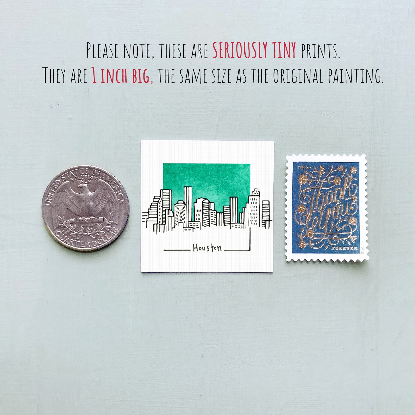 a collection of three objects: a quarter, a small square print of a city skyline, and a postage stamp.