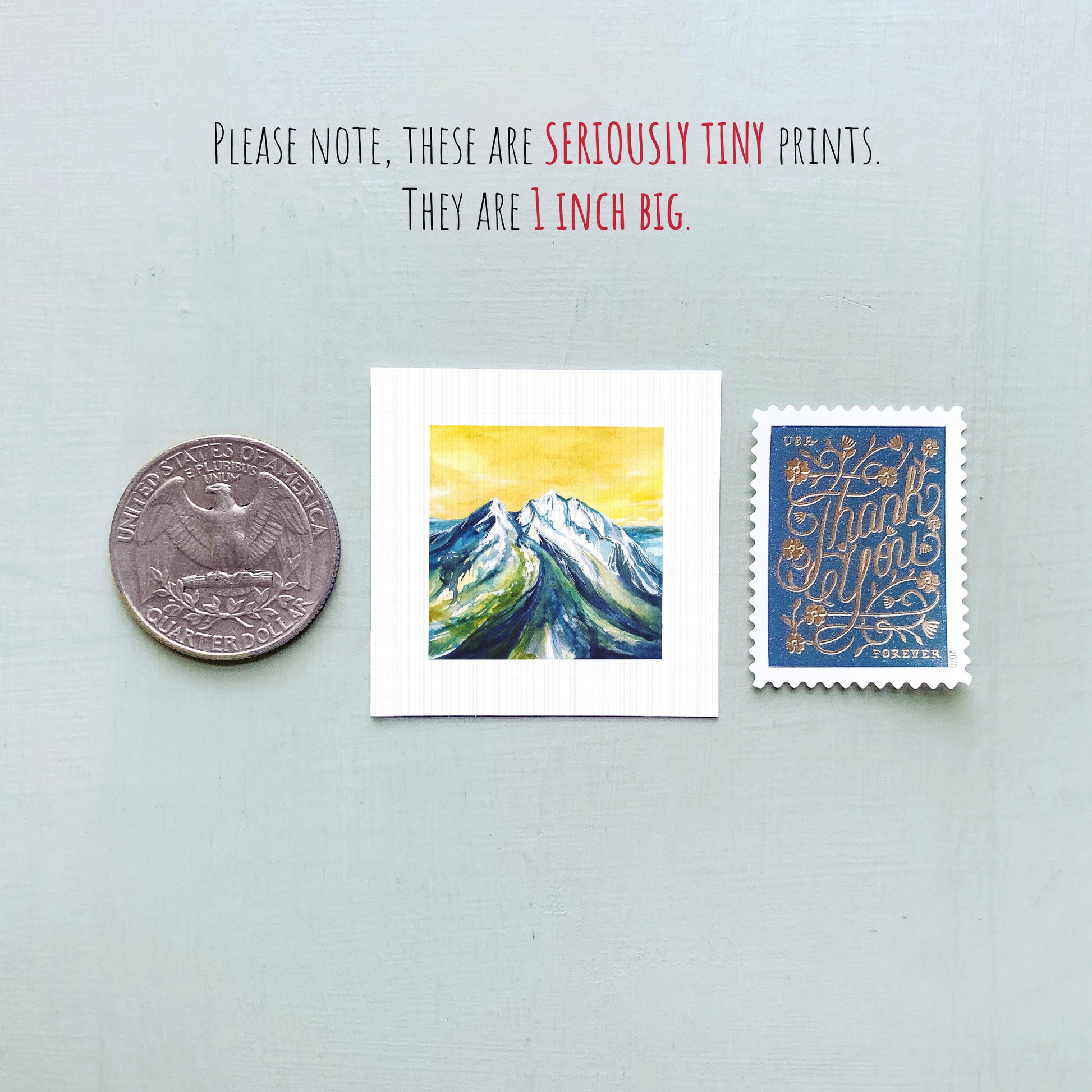 a collection of three small items: a quarter, a postage stamp, and a painting of a mountain landscape.