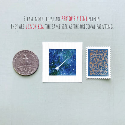 three small prints: a quarter, a square print with a blue background depicting a starry night sky, and a postage stamp with gold lettering.