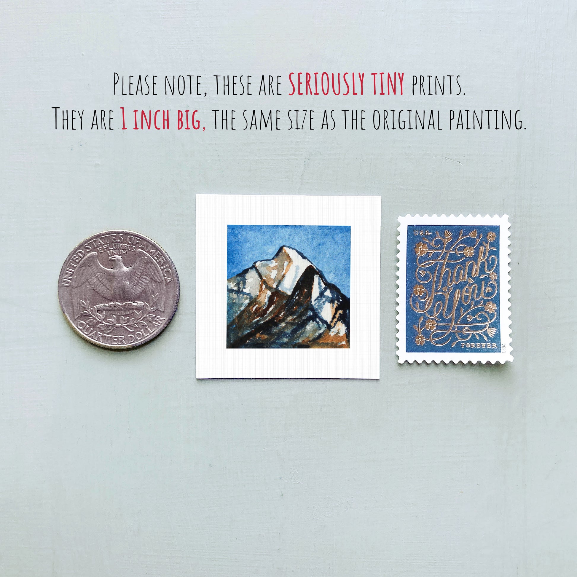 three small prints: a United States quarter, a small square print with a mountain landscape, and a blue postage stamp with gold lettering.