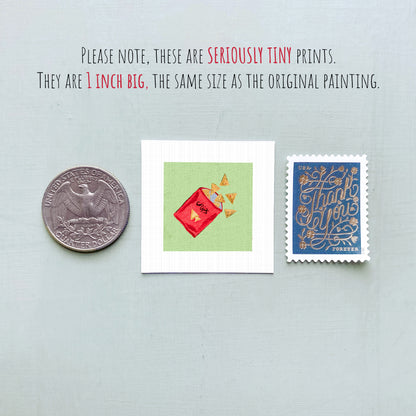three small items: a quarter, a piece of paper with a red and green illustration, and a postage stamp.