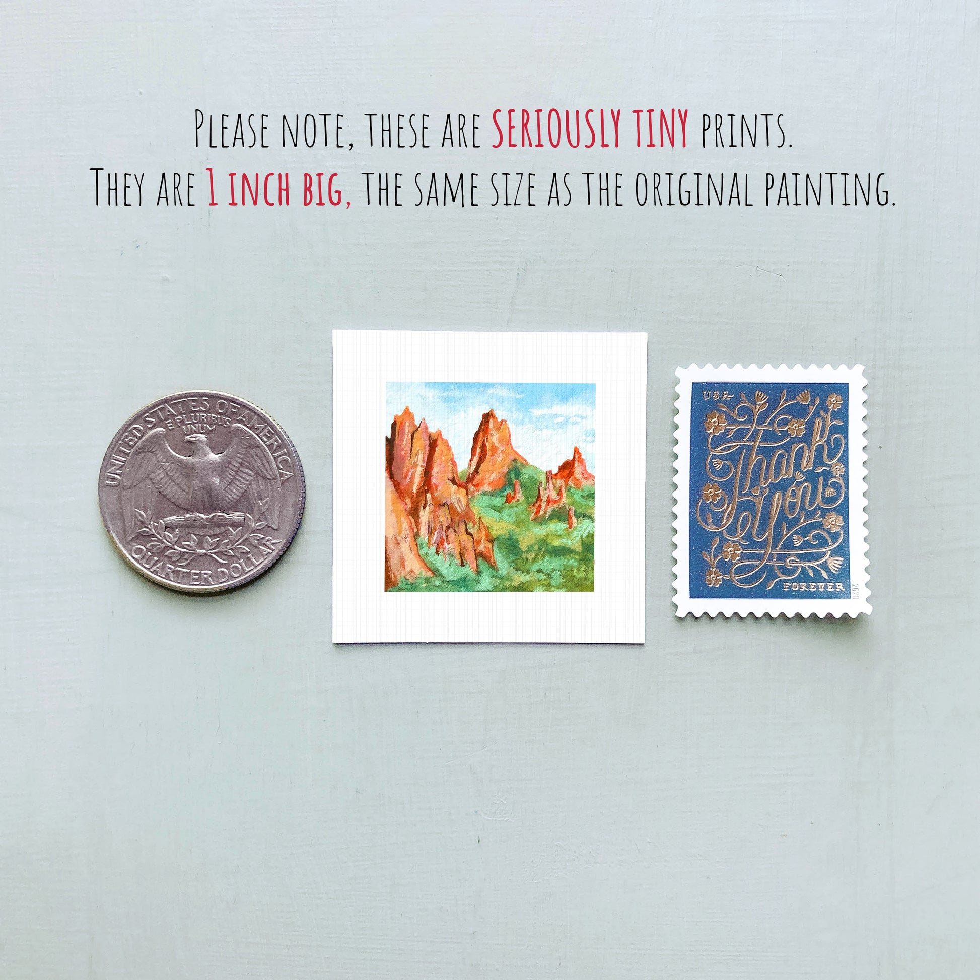 three small prints: a quarter, a postage stamp, and a painting of a mountain landscape.