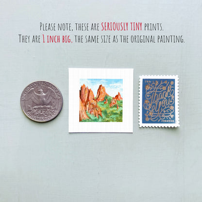 three small prints: a quarter, a postage stamp, and a painting of a mountain landscape.