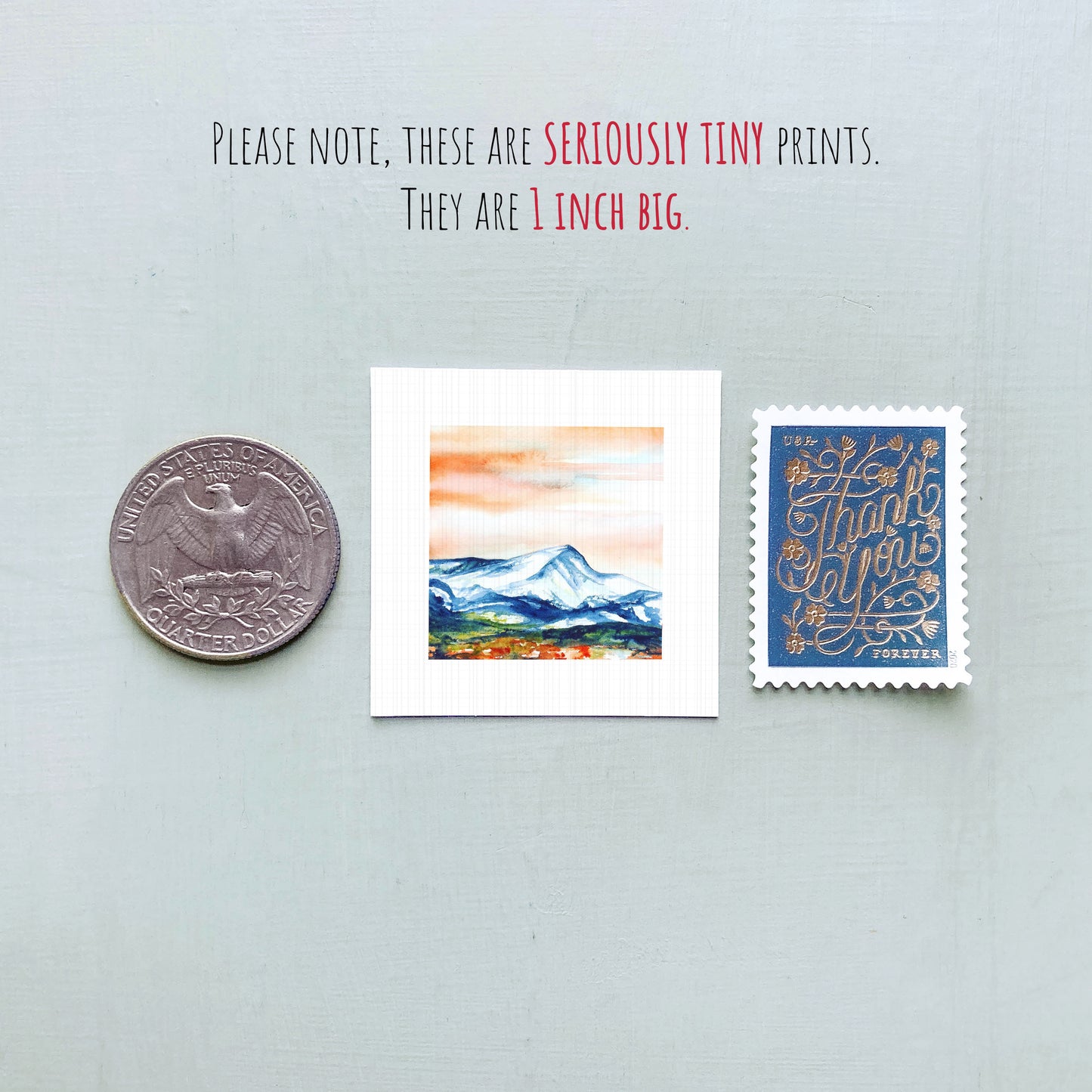 a collection of three small prints, including a United States quarter, a postage stamp, and a painting of a mountain landscape.