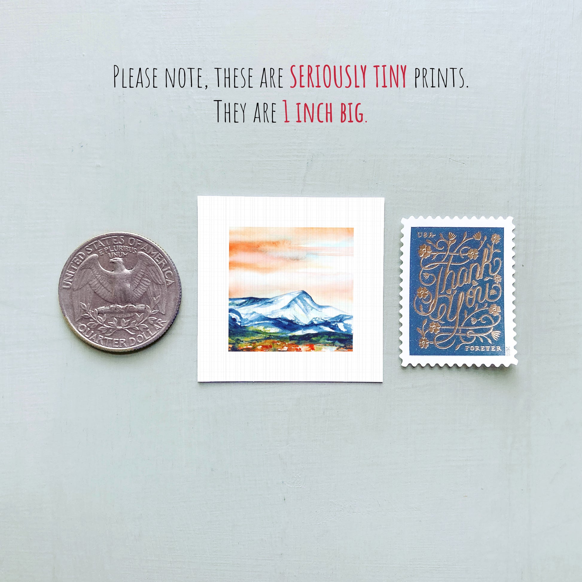 a collection of three small prints, including a United States quarter, a postage stamp, and a painting of a mountain landscape.