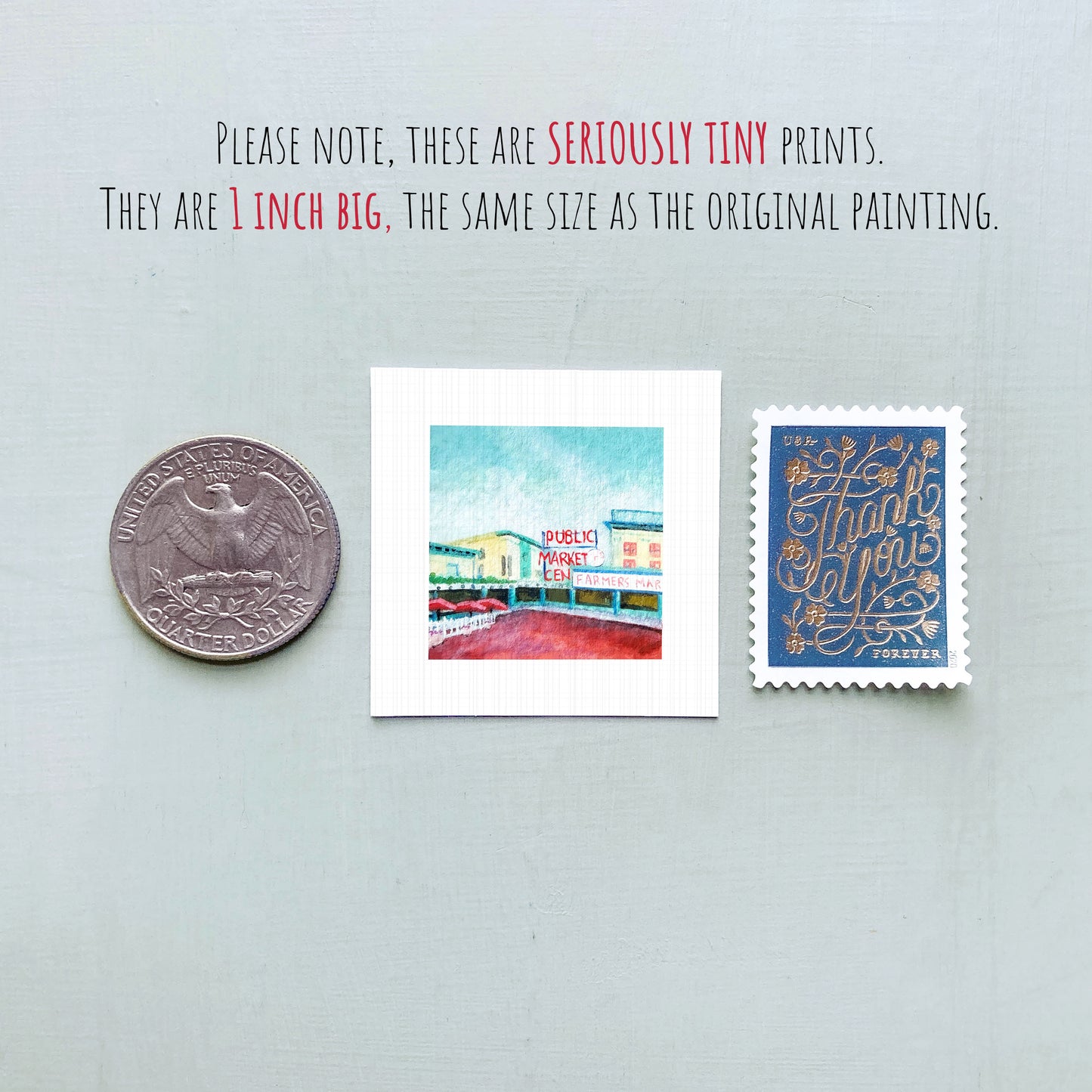 three small prints: a silver coin, a white square print of a building, and a blue postage stamp.