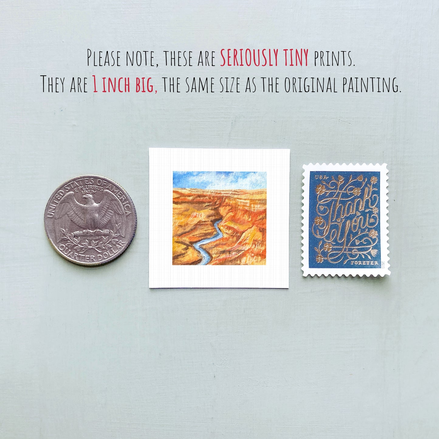 three small prints: a quarter, a postcard with a painting of a desert landscape, and a postage stamp.