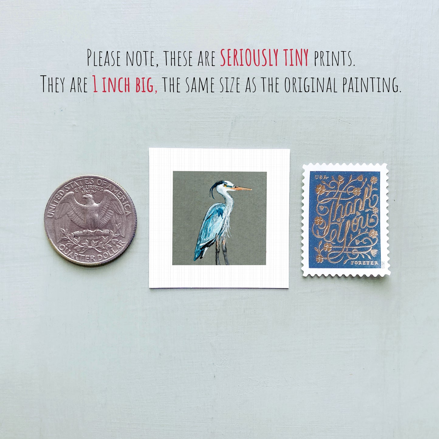 a collection of three objects: a quarter, a postage stamp, and a painting of a blue heron.