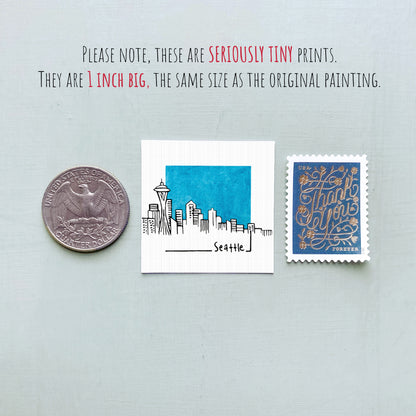 three small items: a silver coin, a white square with a blue city skyline, and a blue postage stamp.