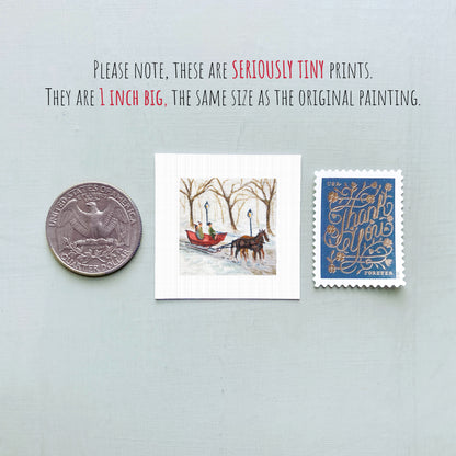 three small art prints and a United States quarter coin, all of which are described as "seriously tiny prints" and "1 inch big," respectively.