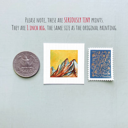 three small artworks: a silver coin, a white square with a colorful painting of mountains, and a blue postage stamp with a floral design.